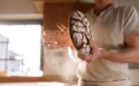 A baker with a rye bread boule
