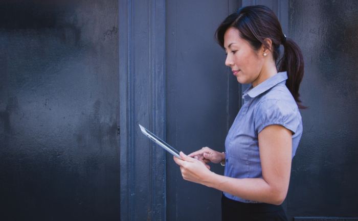 A woman touching a mobile tablet screen